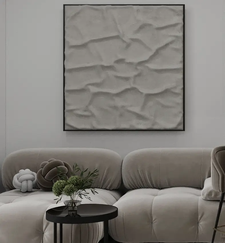 Modern living room with a beige tufted sofa, black round coffee table, and textured square wall art.