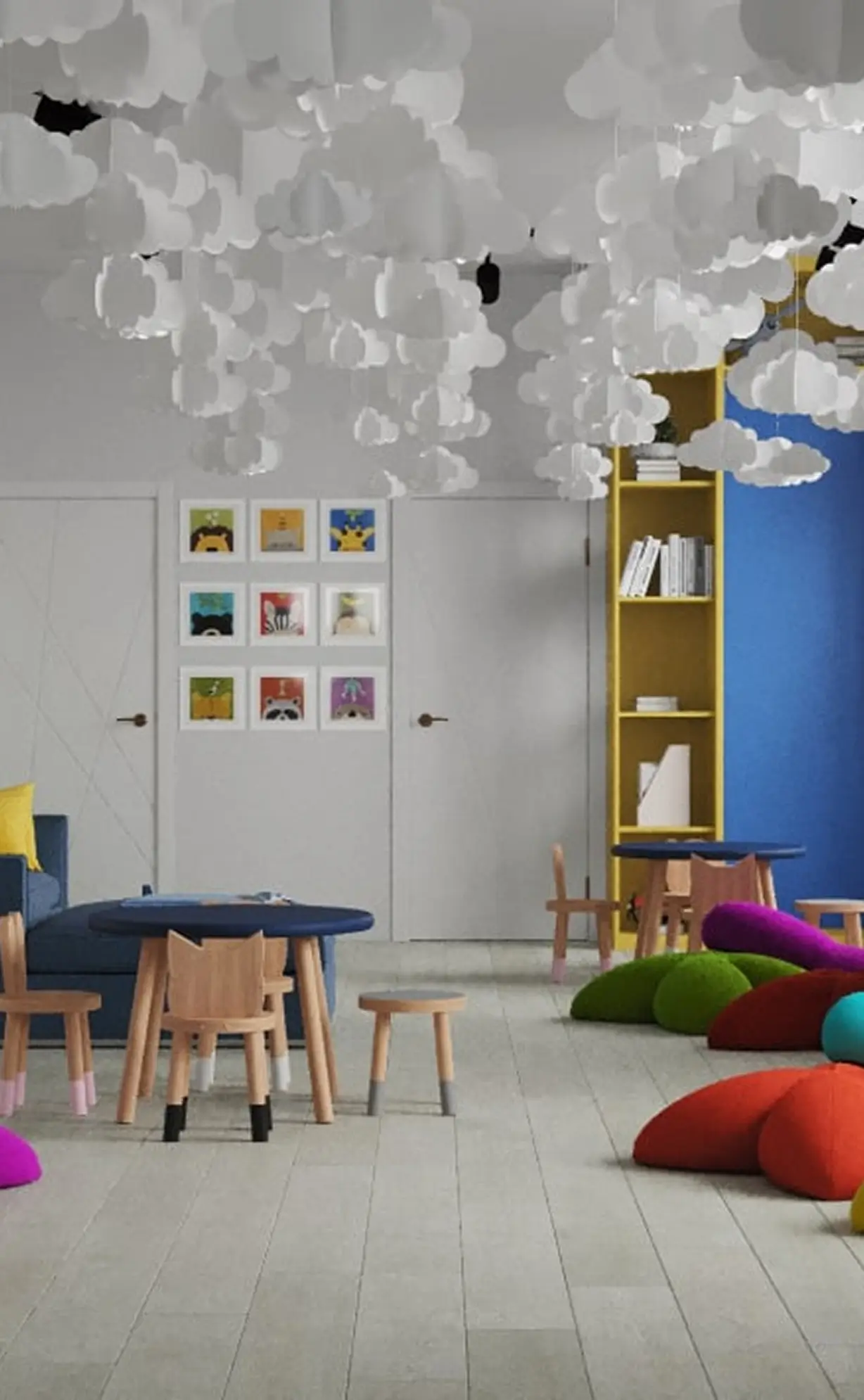 Children's playroom with wooden tables and chairs, colorful cushions, cloud decorations, and framed animal art.