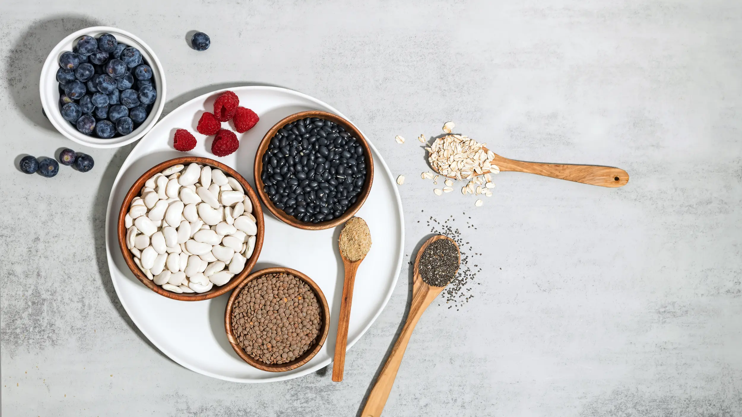 Bowls of high fiber foods such as beans and berries on table