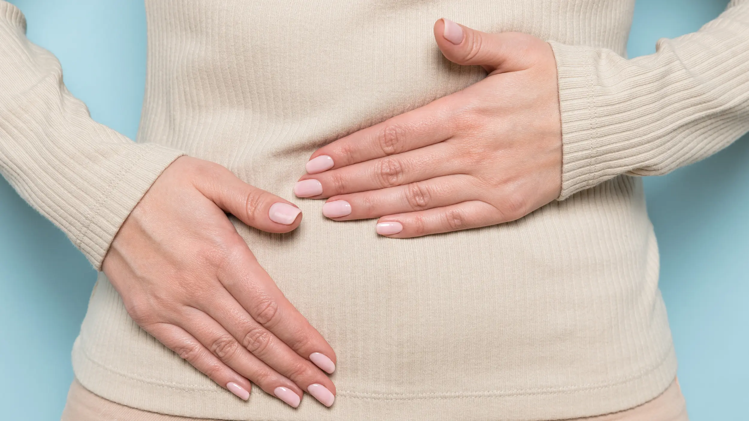 women with her hands on her bloated belly