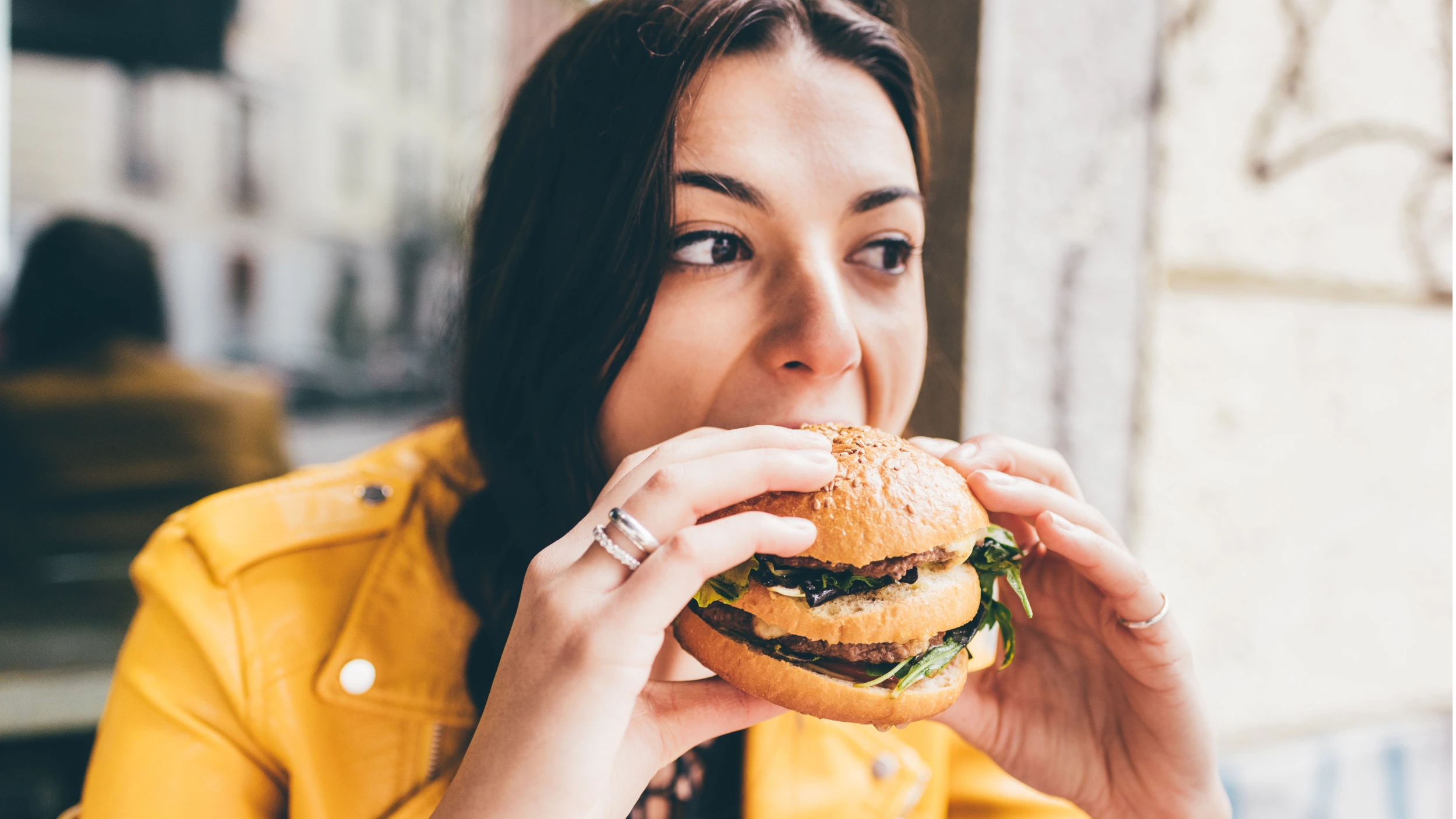 Woman emotionally eating a burger