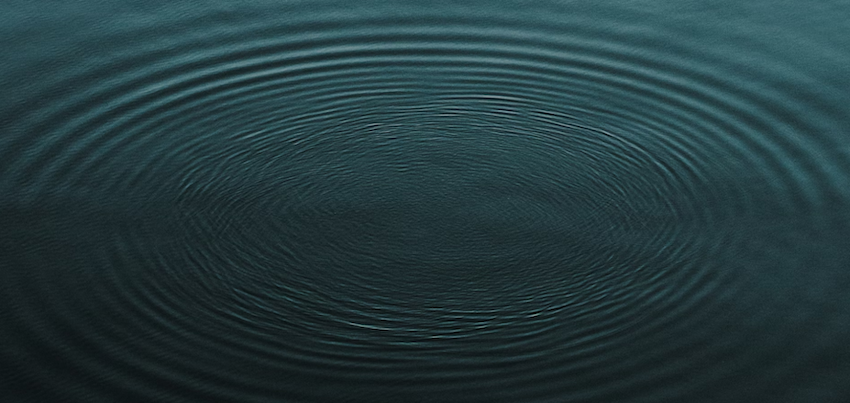 Concentric ripples spreading on the surface of dark water.