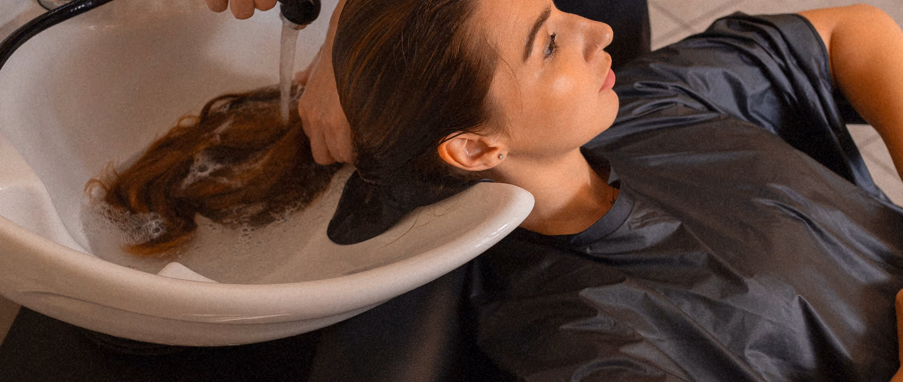 Ein Mädchen bekommt im Schönheitssalon die Haare gewaschen.