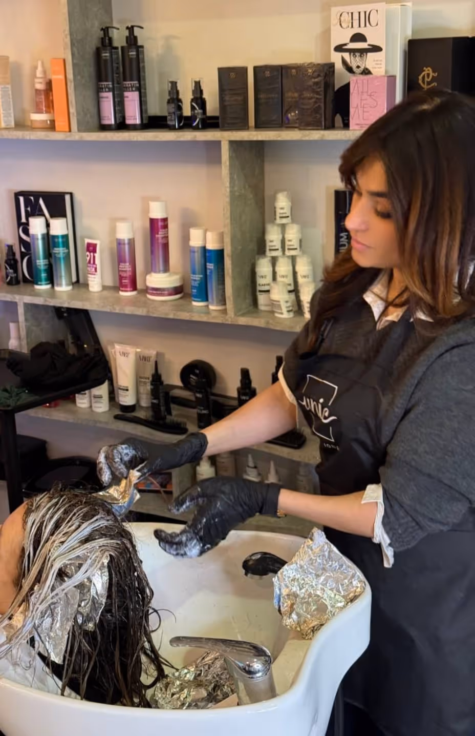 Friseurin schneidet einem Mann mit einer Haarschneidemaschine die Haare.