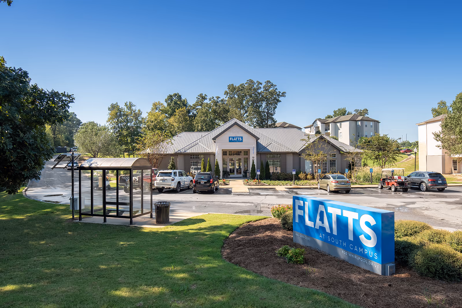 Leasing office exterior with bench and Flatts sign