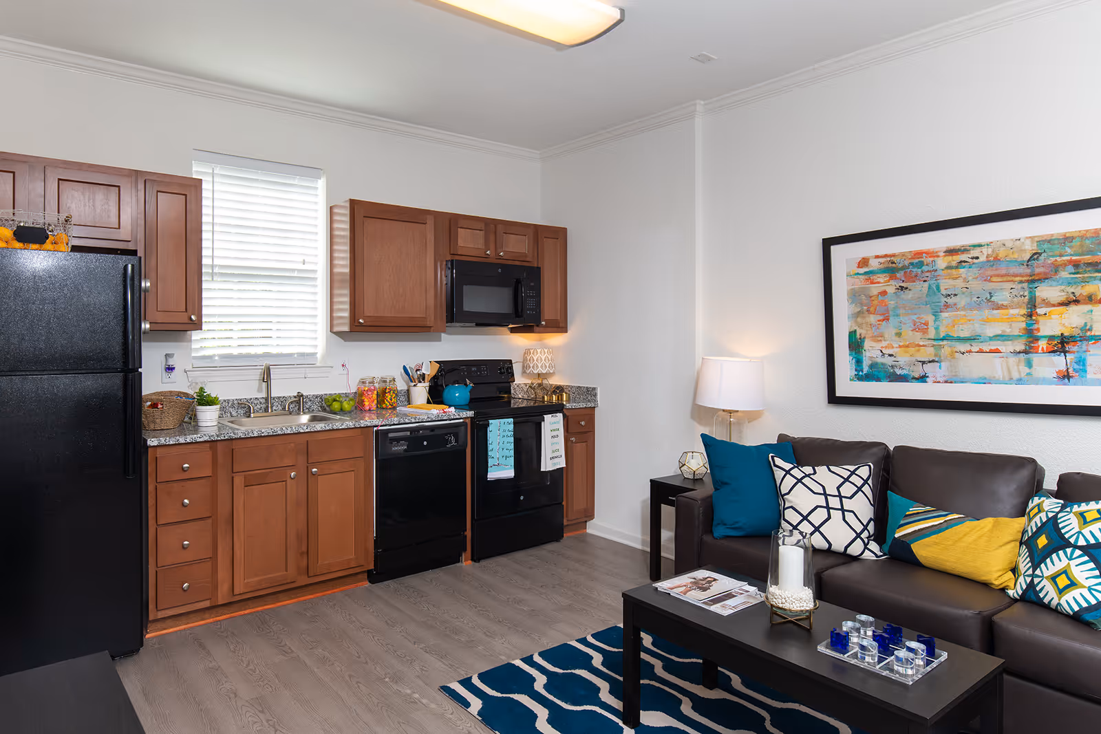Kitchen with black appliances and living area with sofa