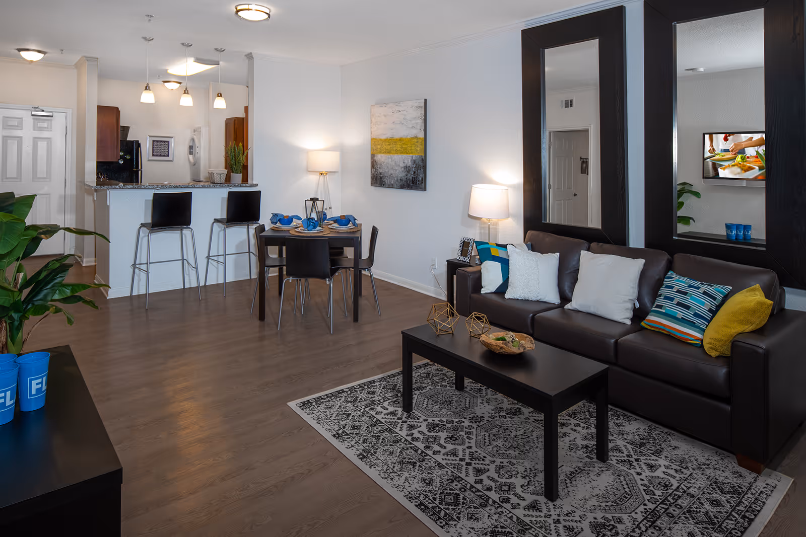 Living area with sofa, coffee table, and rug, and dining area with tables and chairs