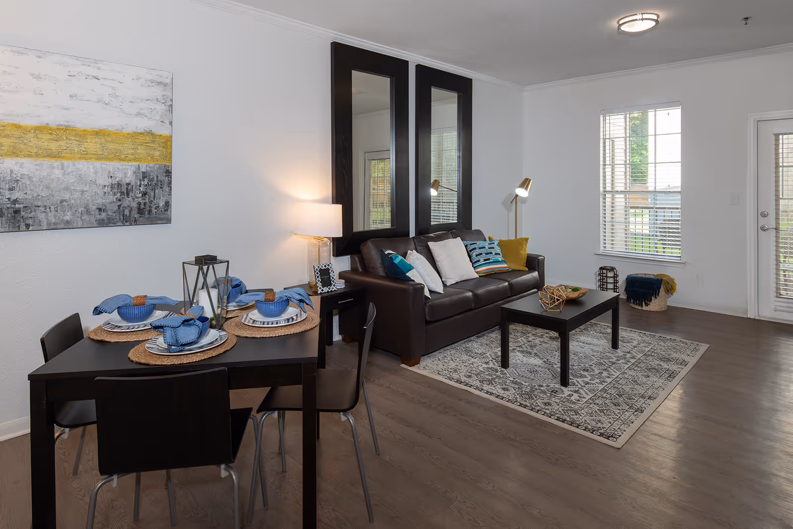 Living area with sofa, coffee table, and rug, and dining area with tables and chairs