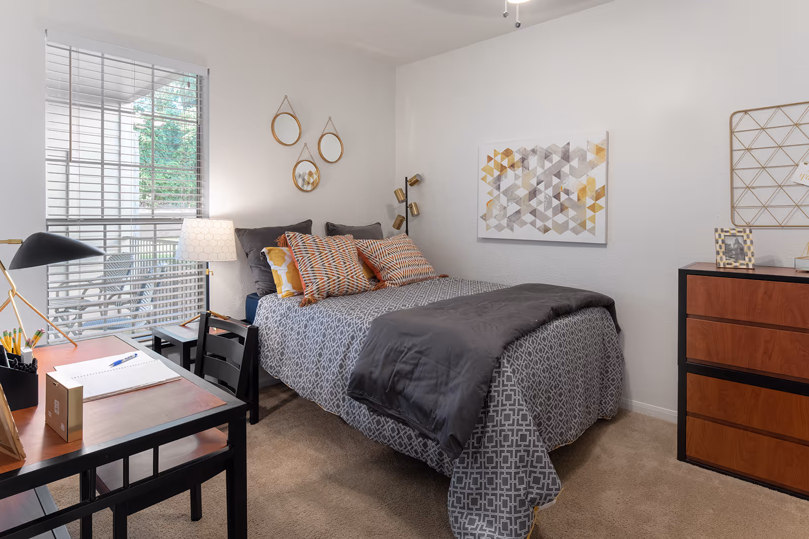 Bedroom with bed, large window, and desk area with chair