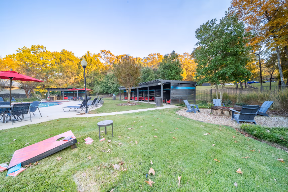 Common area featuring corn hole game, fire pit, swimming pool, and cabanas