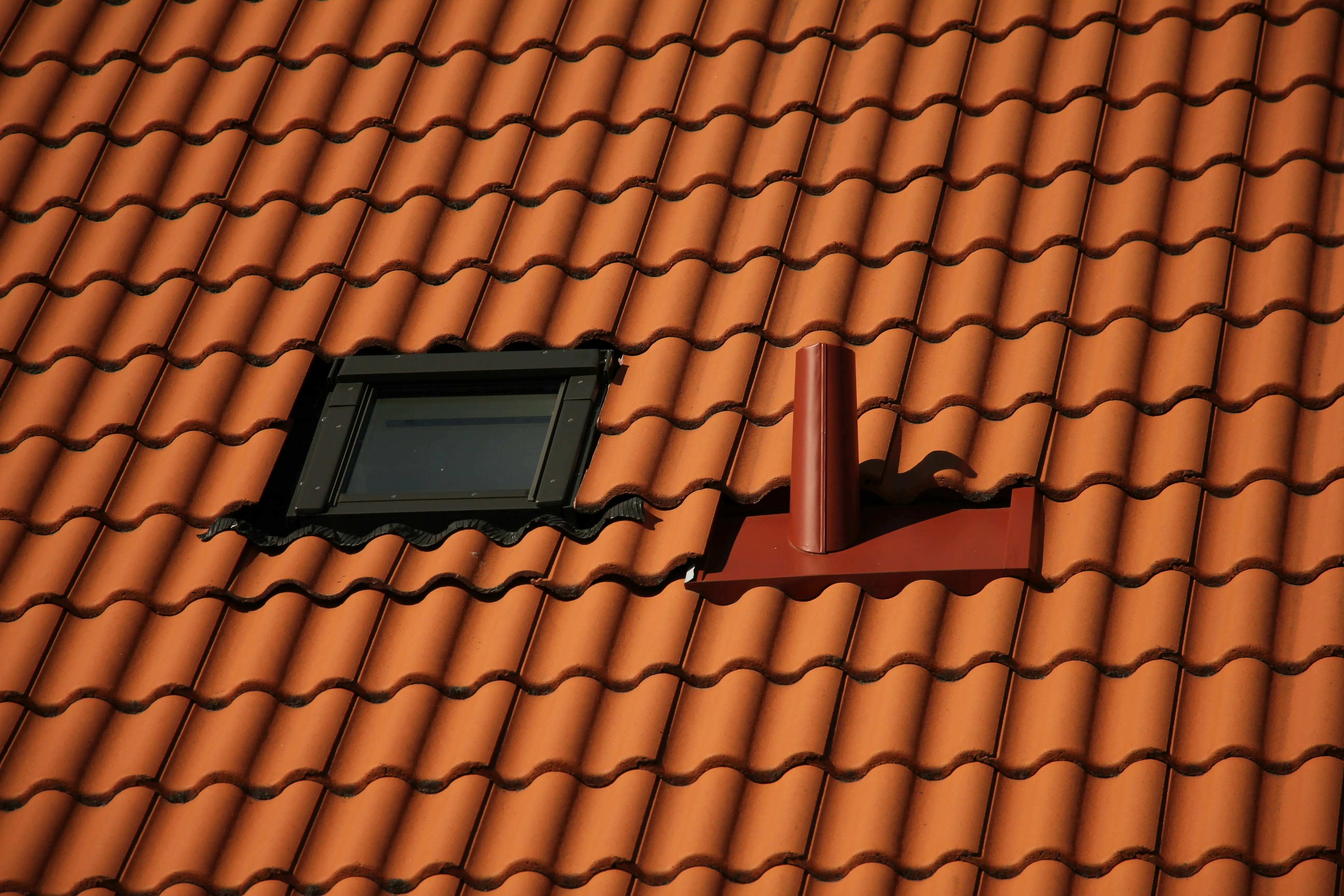 Fenêtre de toit et sortie de ventilation sur toiture en tuiles