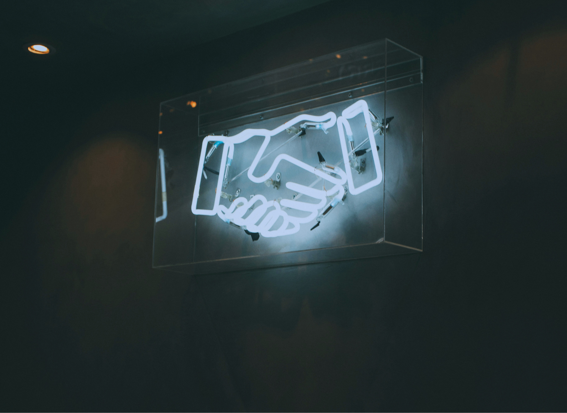 Foto einer Neonröhre in Form von Händeschütteln