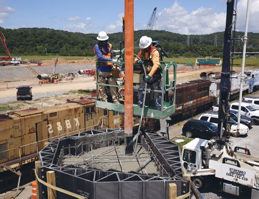 Workers pouring concrete into form