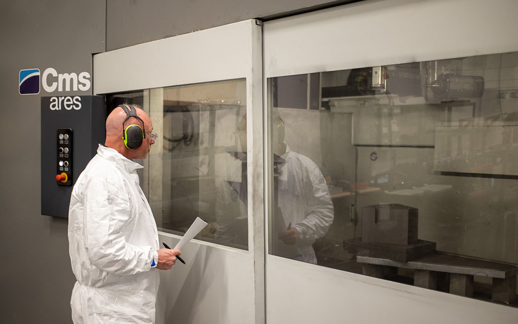 An operator overseeing graphite machining