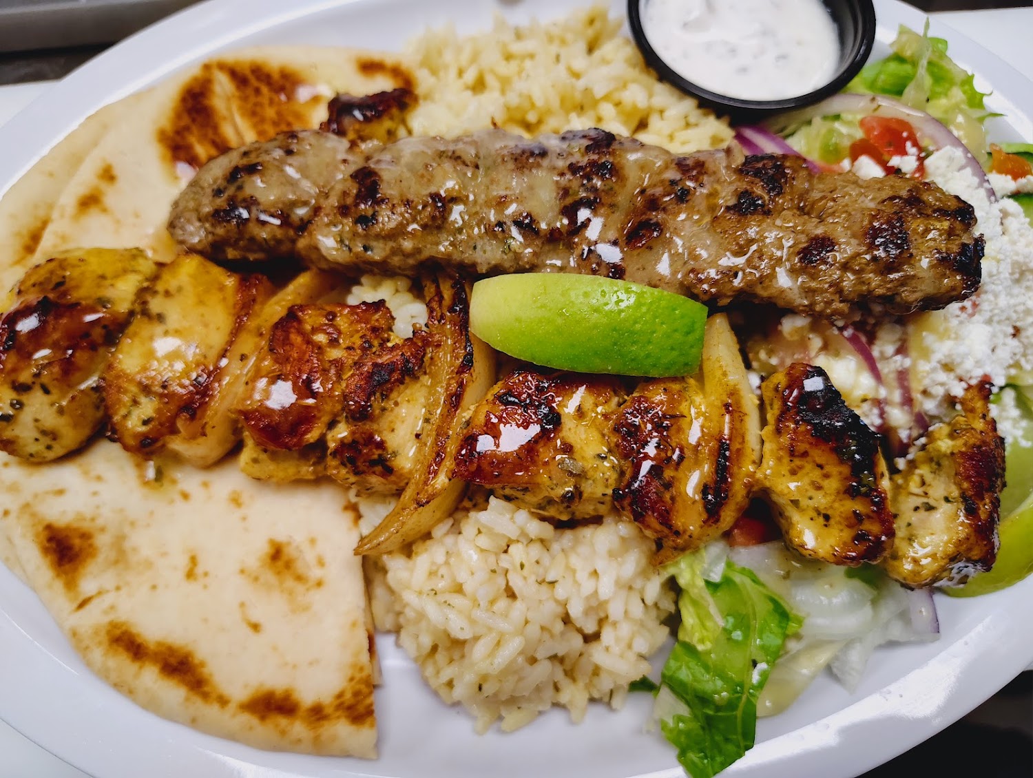 A plate of food with rice, meat, and vegetables.