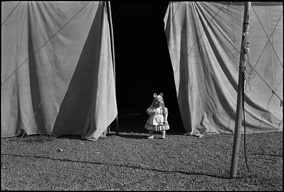 Fotografía de la serie El circo de la fotógrafa chilena Paz Errázuriz, aparece una niña con máscara de Miss Piggy.