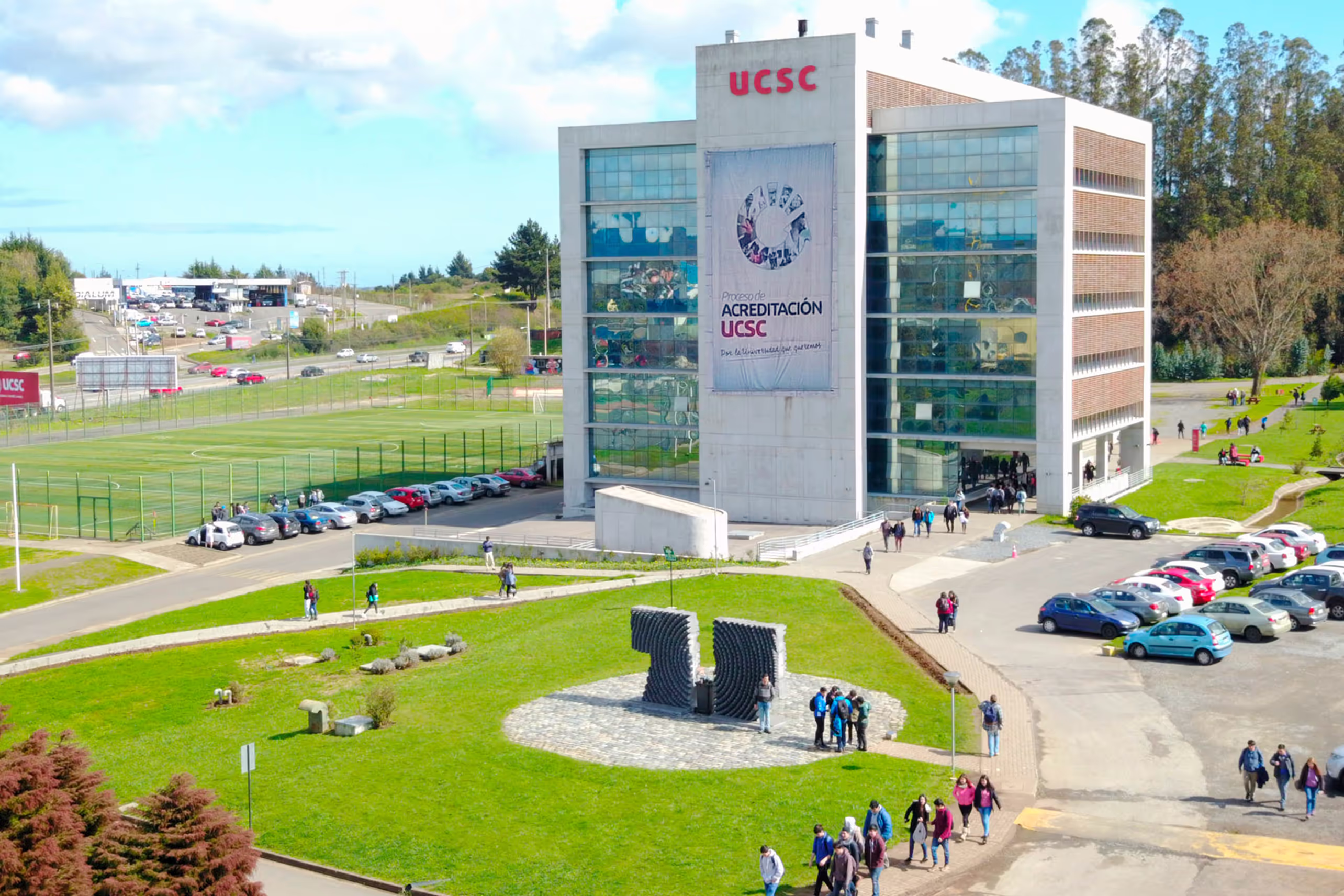 Campus de la Universidad Católica de la Santísima Concepción con un edificio y estudiantes caminando alrededor.