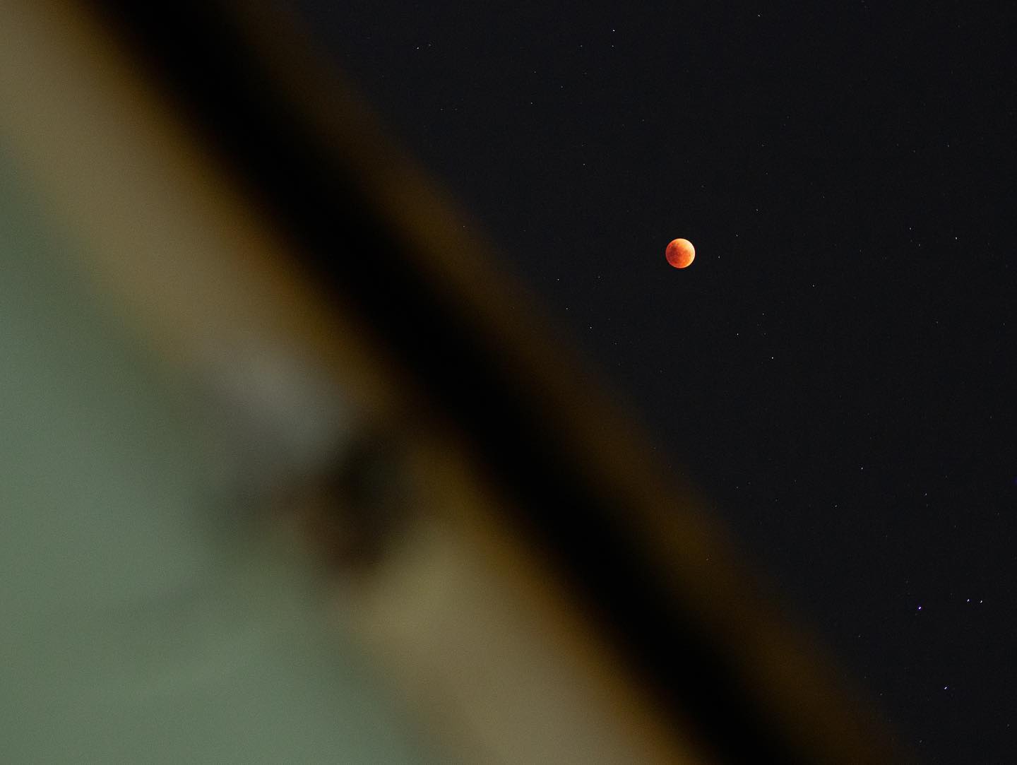 Vista de la luna roja desde una ventana en la ciudad de Santiago.
