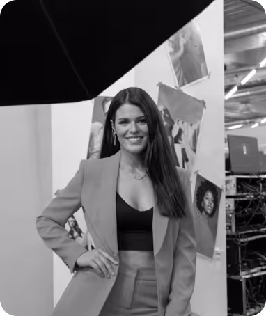 Ann-Katrin Lange smiling in a photo studio with framed pictures in the background.