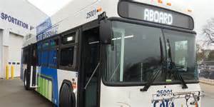 Public transit bus at a transportation facility with a bike rack on the front and the destination sign reading 'ABOARD'.