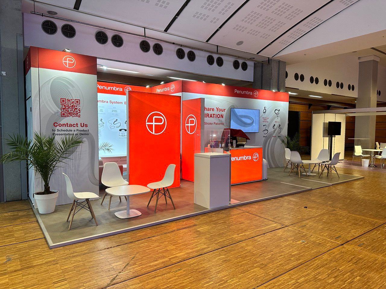 Exhibition stand with branded product displays, reception counter and visitor seating area