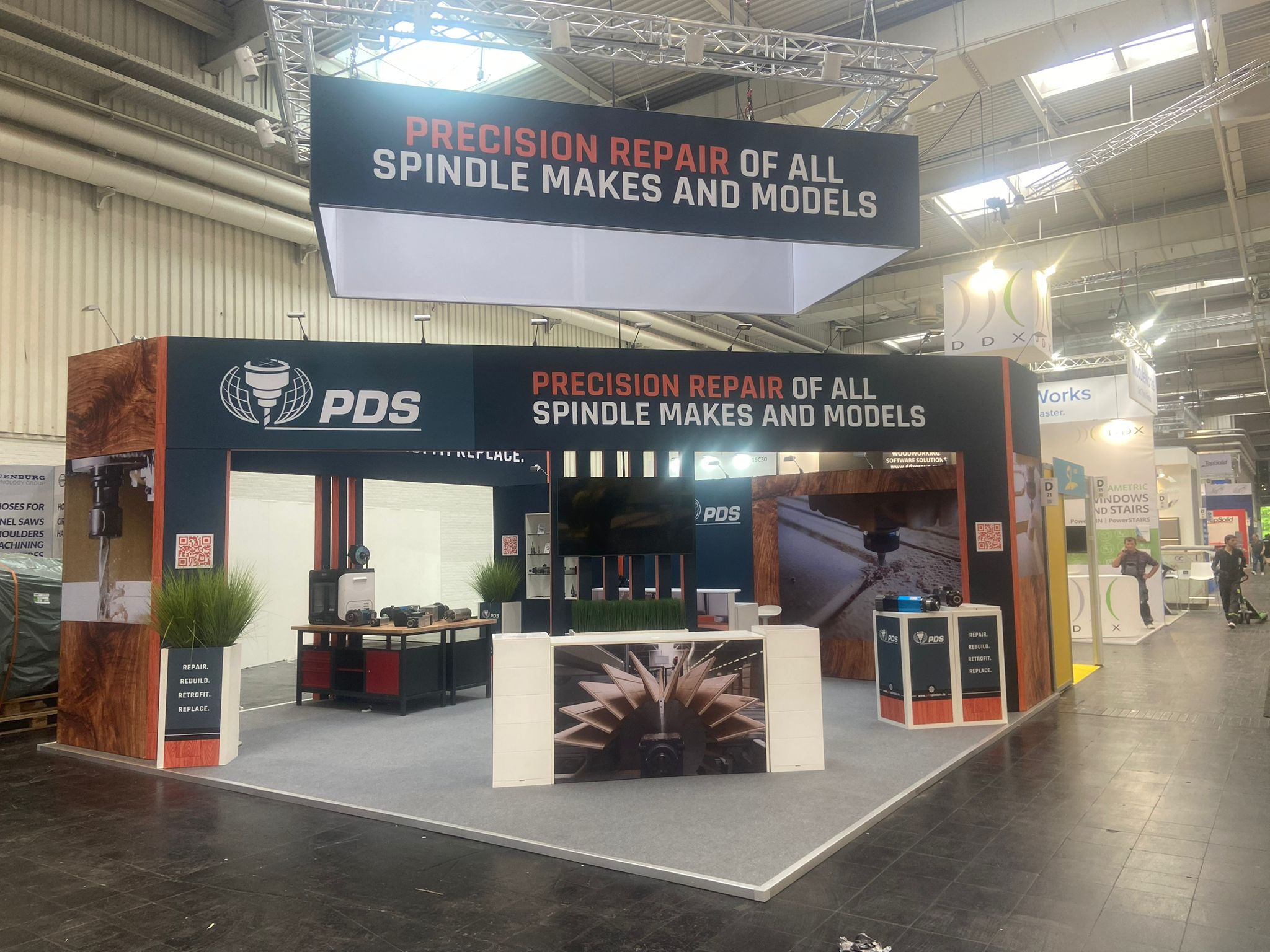 Exhibition stand with suspended branding, product displays and demonstration area