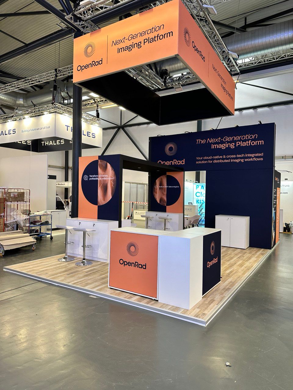 Exhibition stand with suspended branding, product displays and meeting areas