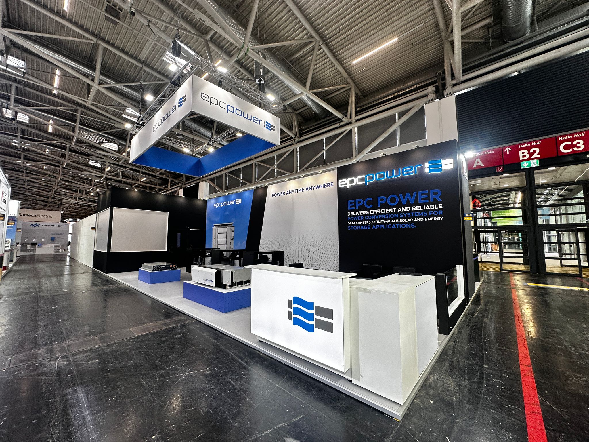 Large exhibition stand with suspended branding, product displays and reception counter