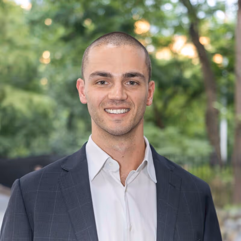 Professional sales man in a professional headshot. Wearing a white shirt and navy jacket against a blurred background. Previously with Argentic Investment Management, placed with Profound. Text overlay reads “Education: Yale University, Past Company: Argentic Investment Management LLC.