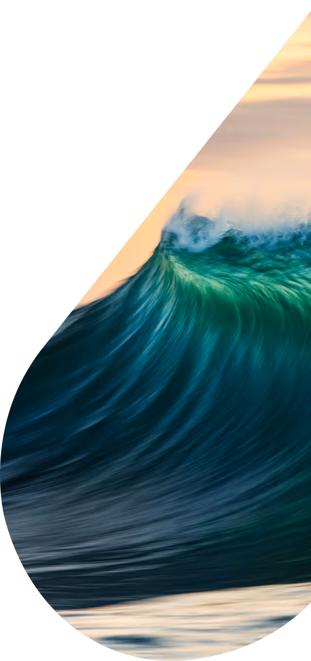 Green and blue sea wave crashing at dusk.