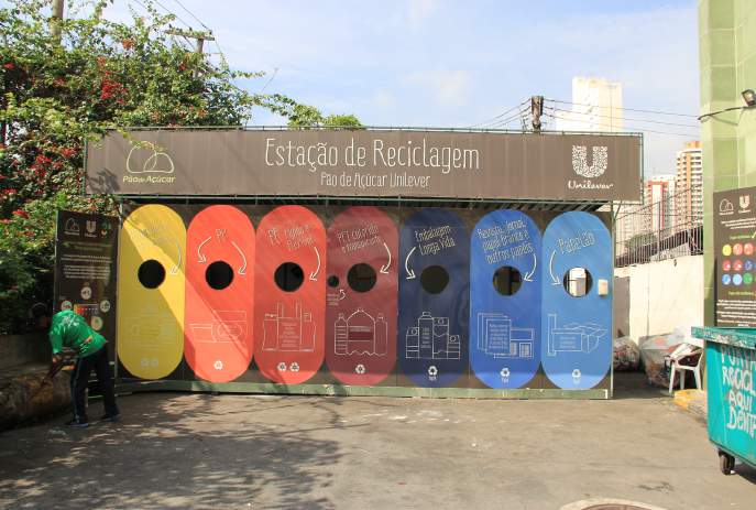 Estação de Reciclagem da Pão de Açúcar Unilever com compartimentos coloridos para diferentes tipos de resíduos, incluindo papel, plástico e alumínio.