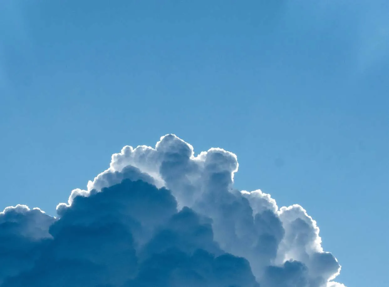 Nuvem branca e fofa brilhando contra um céu azul claro.