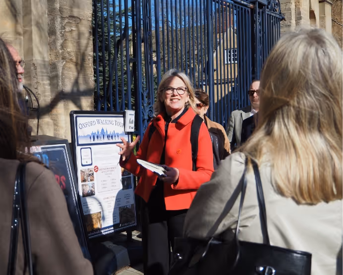Tracy Camilleri leading a walking tour near an Oxford Walking Tours sign, speaking to a group.