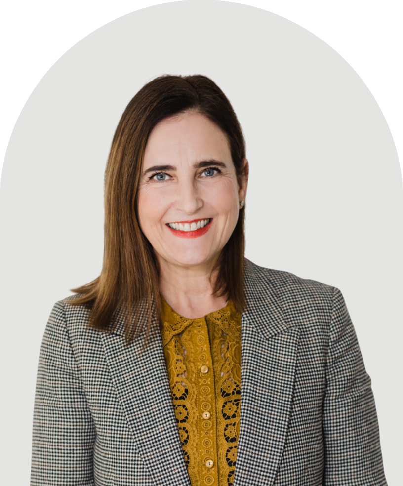 Samantha Rockey with straight brown hair wearing a checkered blazer and mustard lace blouse.