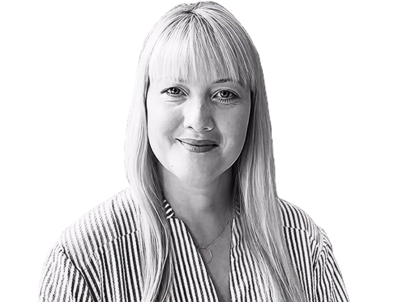 Tracey Camilleri headshot in black and white. Tracey has blonde shoulder length hair and is wearing glasses