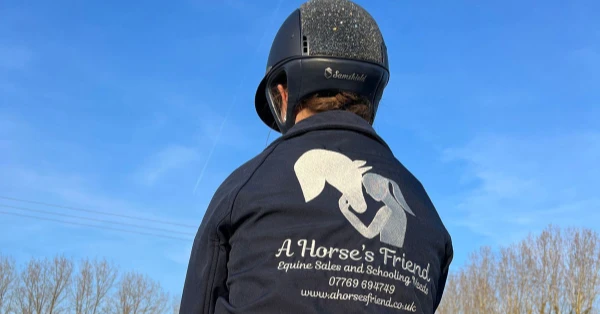 Rider wearing A Horse’s Friend jacket on a pony at a showground in Essex, promoting equine sales and schooling livery services.