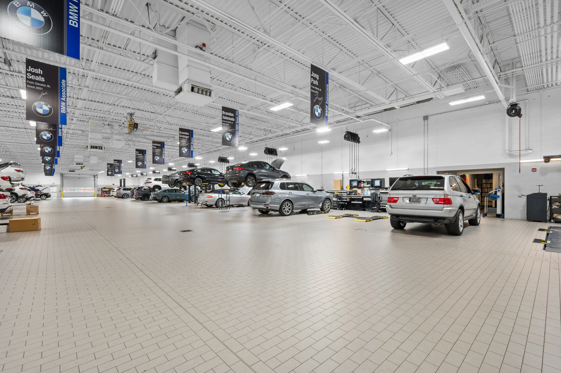 Collision center shop room floor filled with vehicles.