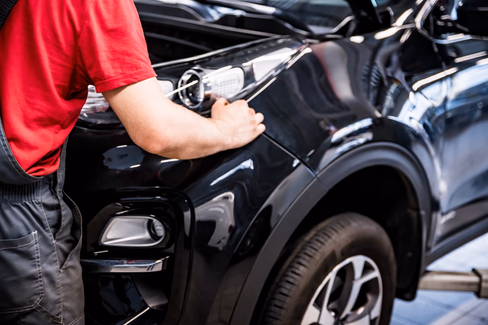 Collision repair professional working on the headlight of a car.