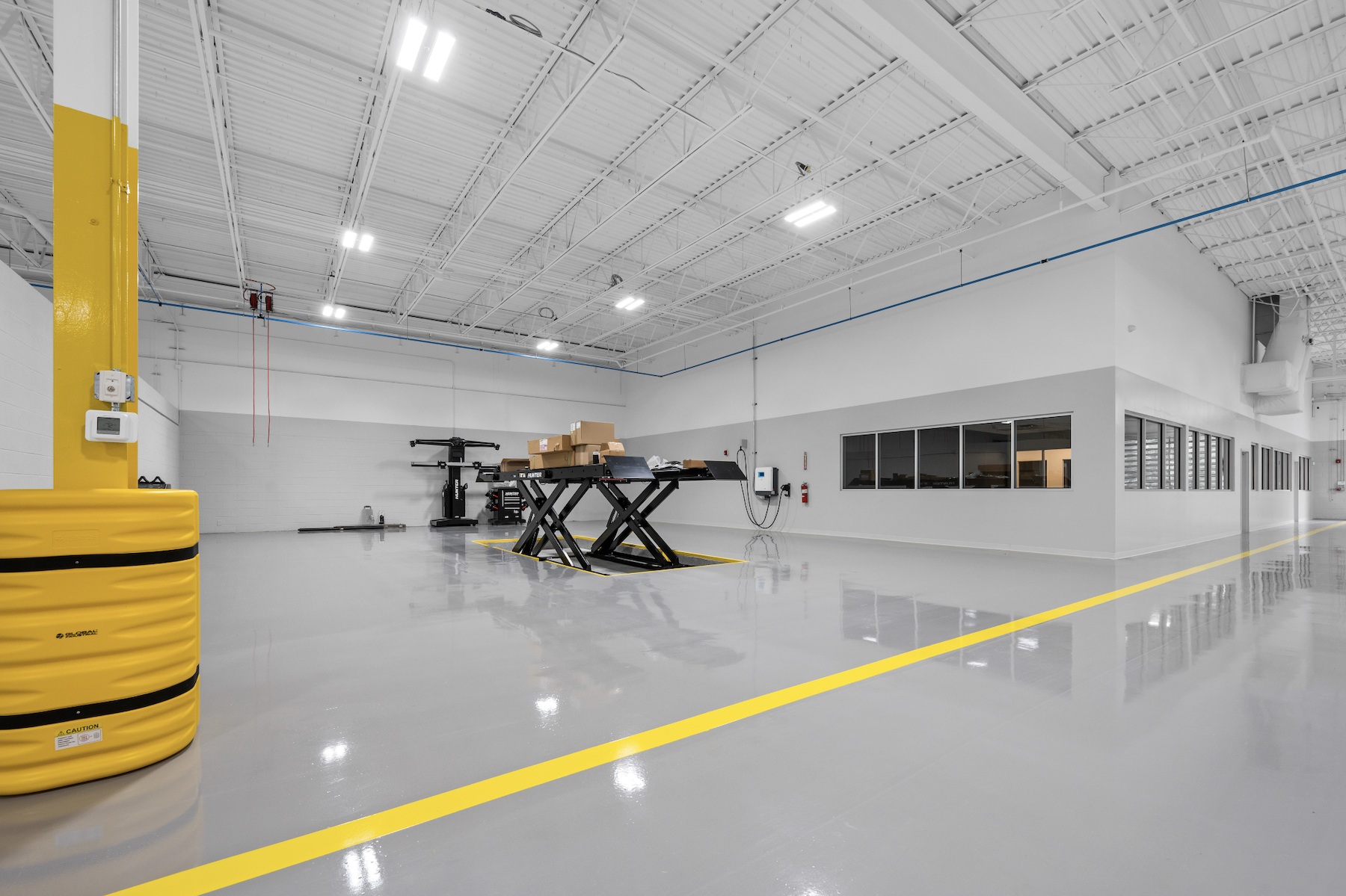 Repair room floor with car lift at Century Collision Center.
