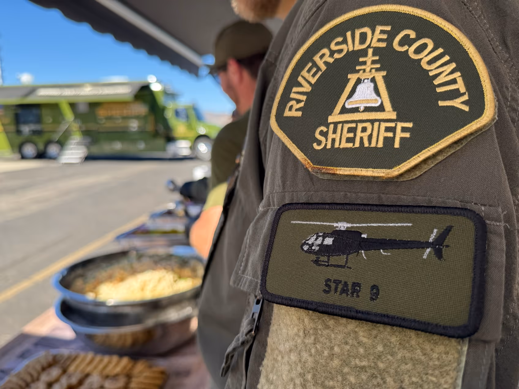Close-up of a Riverside County Sheriff uniform patch and a Star 9 helicopter patch on the sleeve.