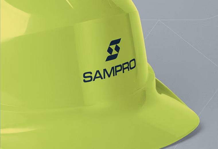 Close-up of a lime green safety helmet with the blue SAMPRO logo on the front.
