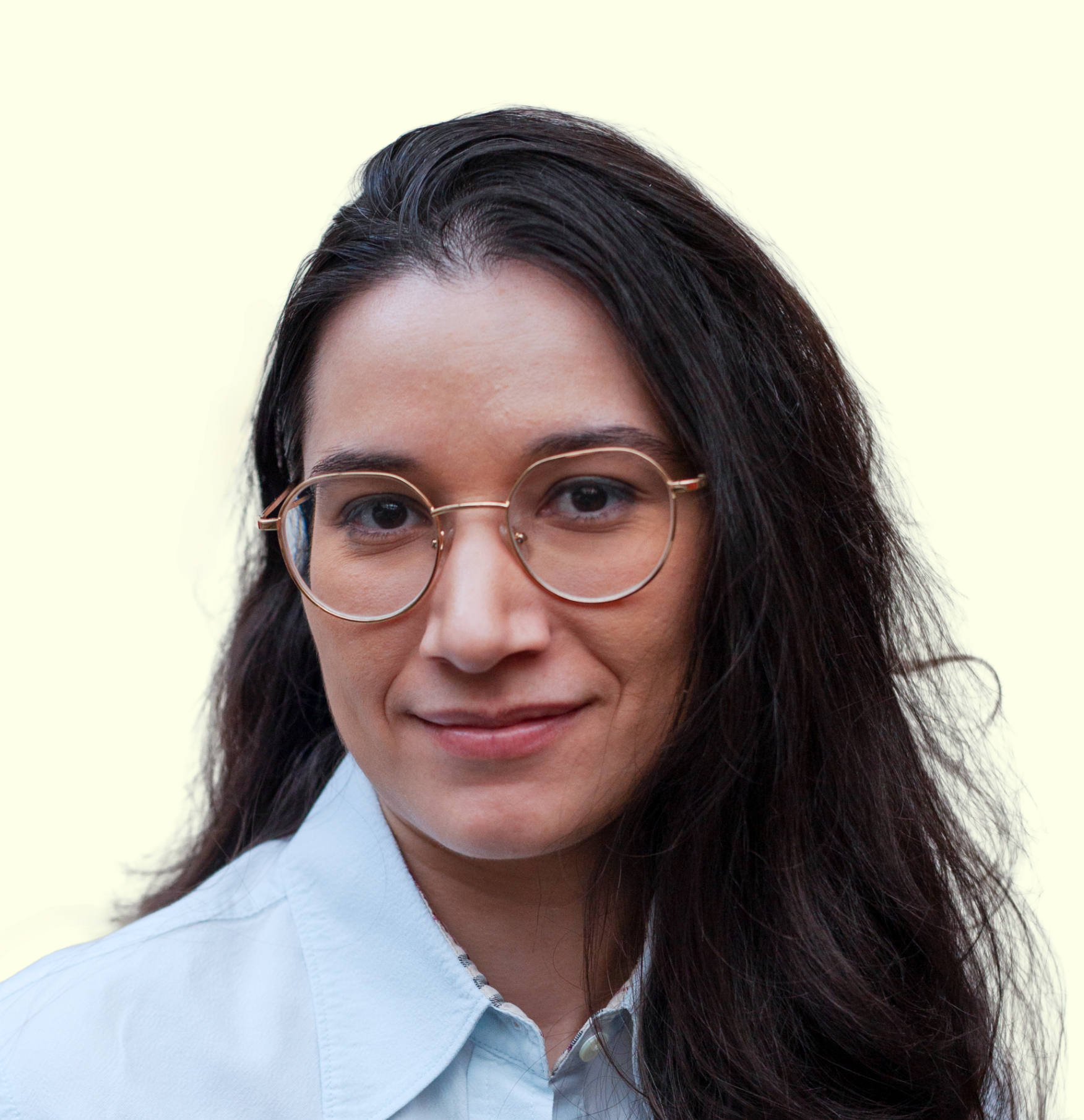 Jeune femme brune aux cheveux mi-longs en chemise bleu ciel.
