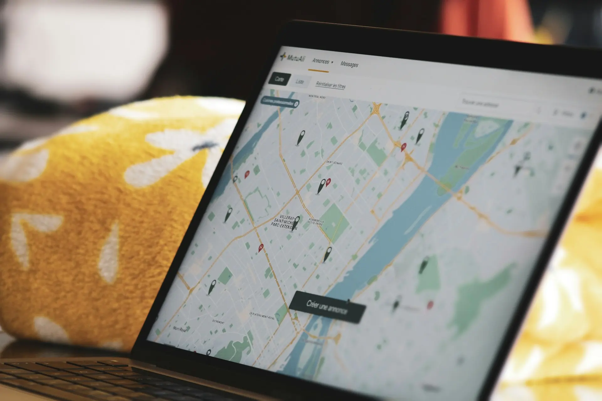 Laptop screen showing a city map with location markers and French interface elements.