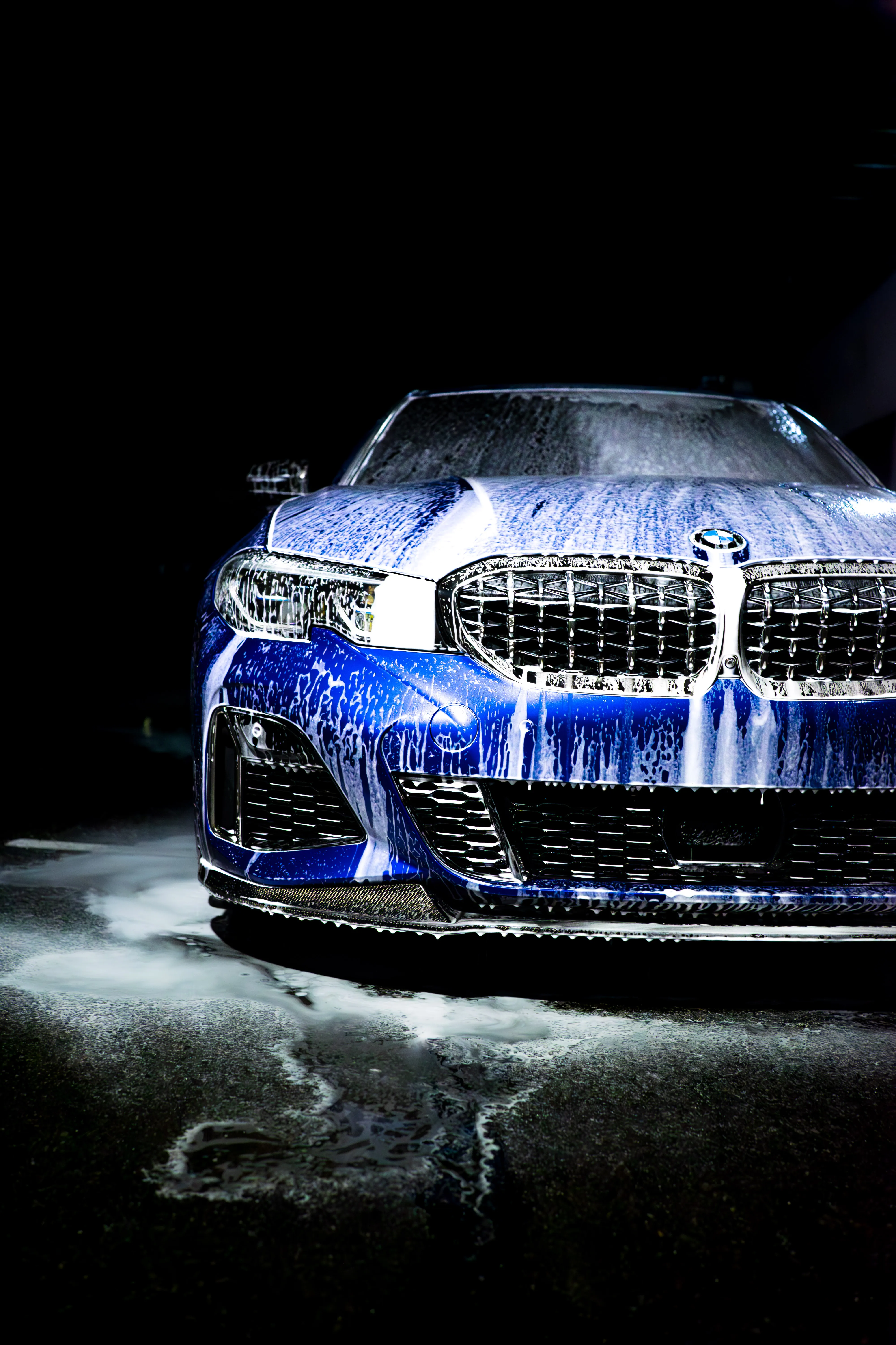 Blue BMW sedan covered in foam during a hand wash at GAS Detailing in Auburn, WA