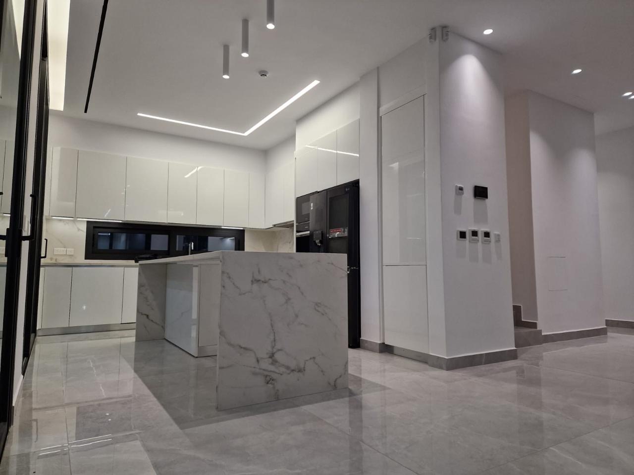 Completed kitchen with marble island and gloss cabinetry, Sea Caves villa, Paphos