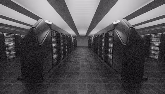 Interior view of a dimly lit data center server room with rows of large server racks on both sides.