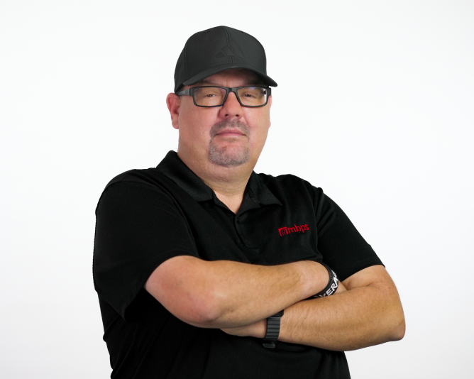 MBPS managed IT support technician in branded polo shirt standing with arms crossed, Phoenix MSP team member