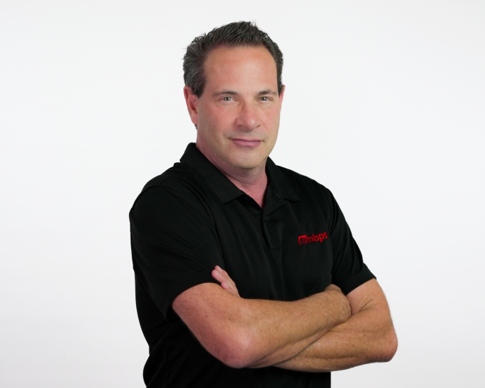 MBPS managed IT services professional in branded polo shirt with arms crossed, Phoenix MSP team member