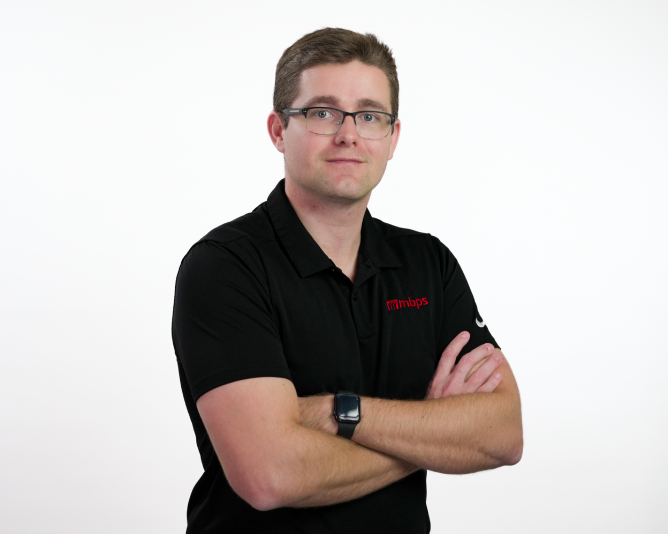 MBPS managed IT support technician in branded polo shirt with arms crossed, smiling confidently