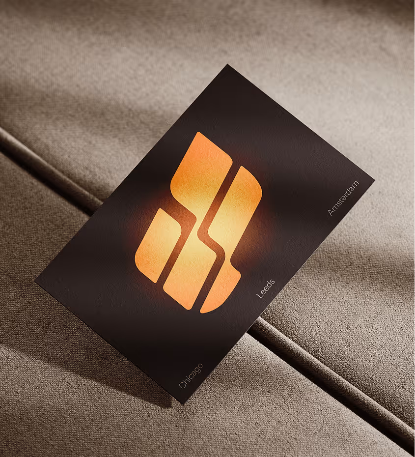 Black card with an abstract orange gradient logo placed diagonally on a brown textured fabric surface, with the city names Chicago, Leeds, and Amsterdam around the edges.